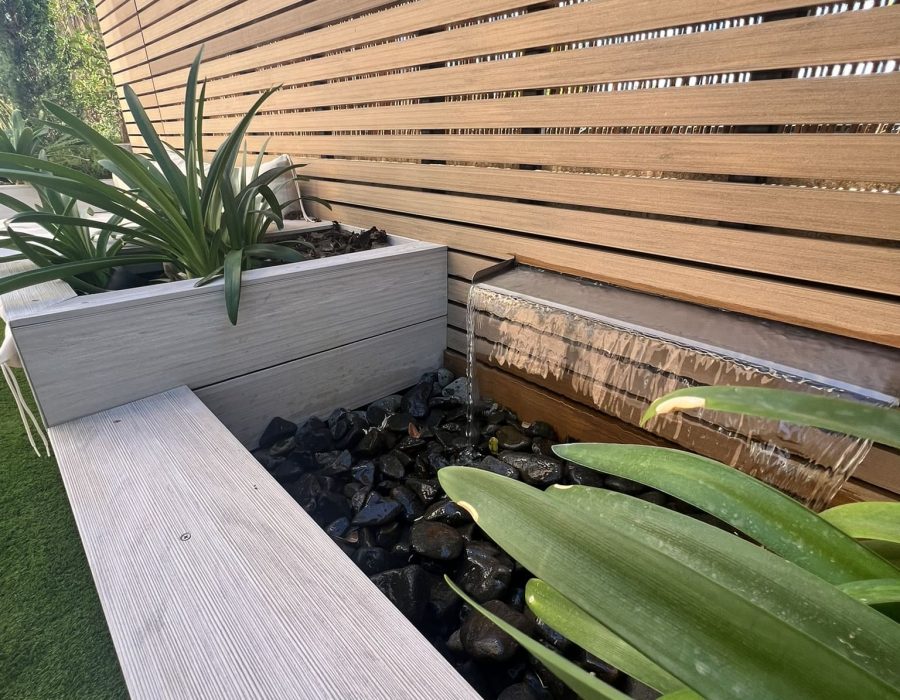 Detalle de cascada de agua junto a banco y jardinera de composite en jardín en Majadahonda — Abierto al Jardín