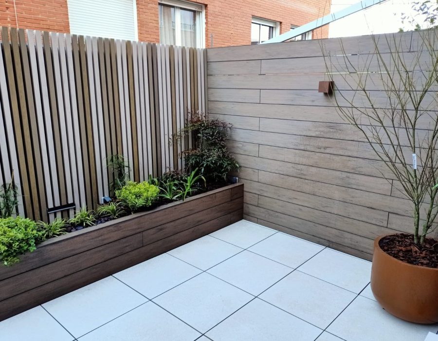 Esquina de panelado de madera con maceta de acero corten en terraza en San Sebastián de los Reyes — Abierto al Jardín