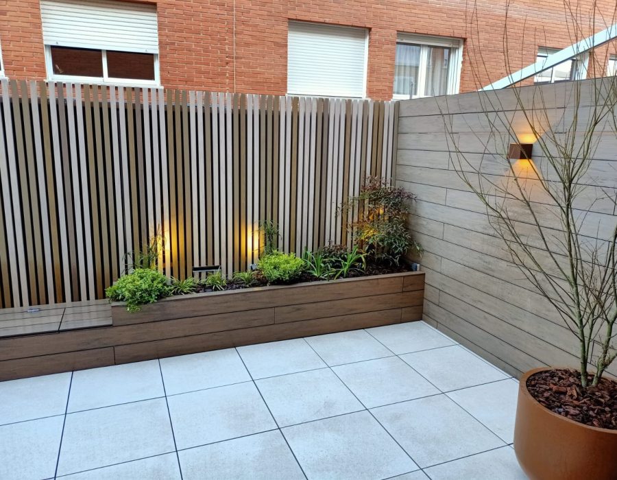Panel de lamas con iluminación y árbol joven en maceta en terraza en San Sebastián de los Reyes — Abierto al Jardín