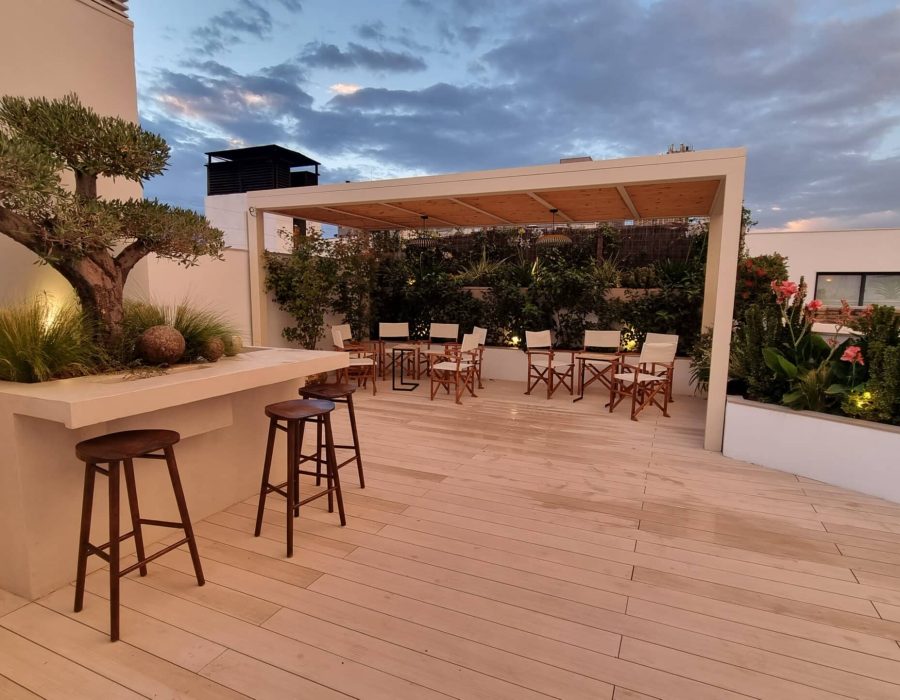 Pérgola de madera con barra exterior y olivo en ático en Castellana, Madrid — Abierto al Jardín